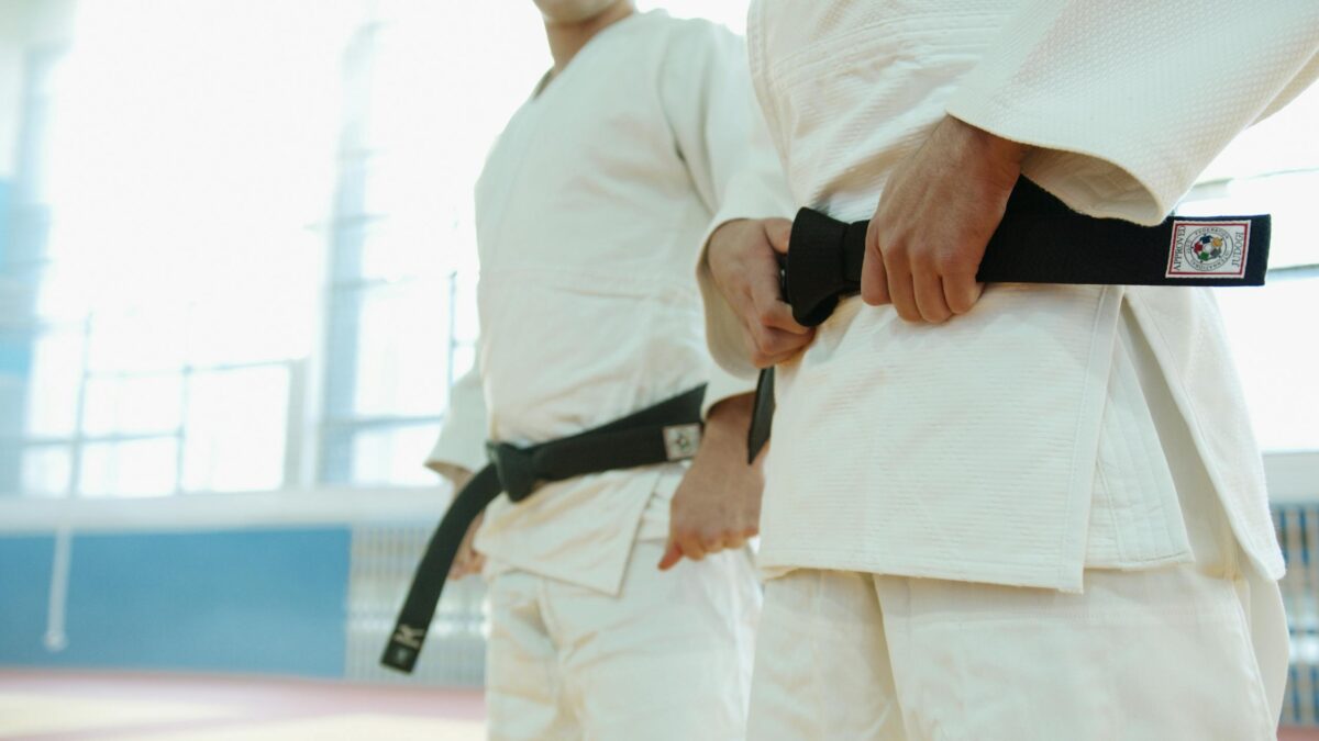 Close-Up Shot of Two People Wearing Karategi and Black Belt